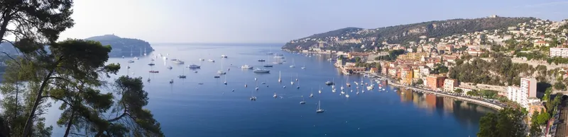 Panoramablick auf die Bucht von Villefranche-sur-Mer an der Côte d'Azur mit zahlreichen Segelbooten.